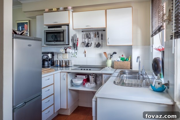 DIY Kitchen Upgrades That Won't Break The Bank 2 A pristine, bright kitchen with white cabinets, a subway tile backsplash, and a large kitchen island with a stainless steel sink, highlighting custom storage solutions.