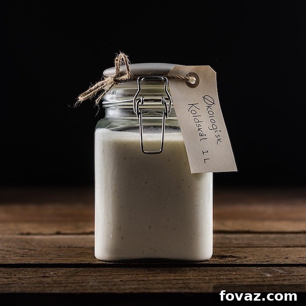 Pouring homemade vanilla extract into a bottle with a funnel