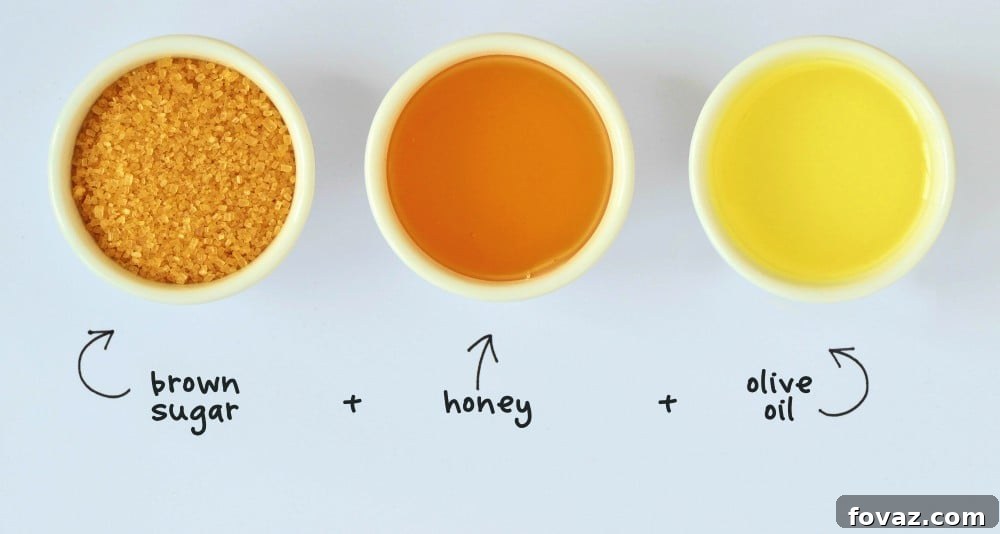 Pamper Your Feet: DIY Home Spa Foot Scrub 2 Homemade foot scrub made out of brown sugar, honey and olive oil in a glass jar, with ingredients scattered around on a white background, highlighting a natural DIY foot spa recipe.