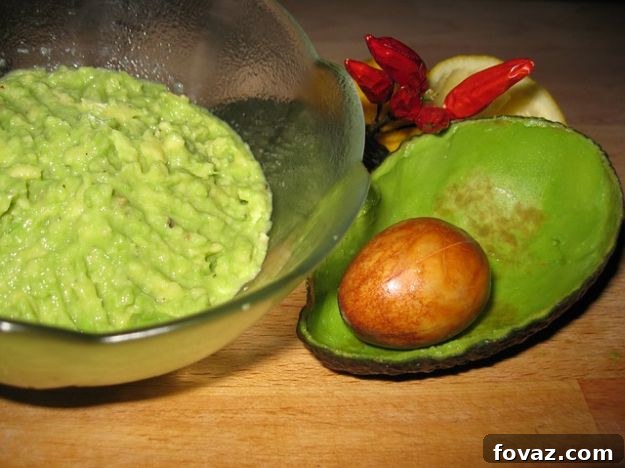 Two halves of avocado with baked eggs inside, garnished with fresh herbs, a perfect quick Paleo breakfast.