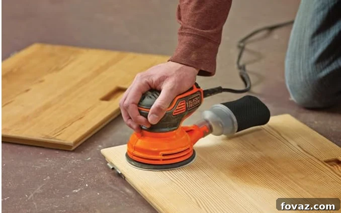 Random orbital sander smoothly stripping a flat furniture surface
