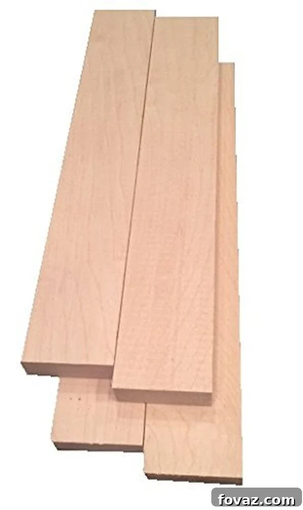 A selection of raw lumber planks including maple, walnut, pine, and cherry, highlighting different wood grains and colors.